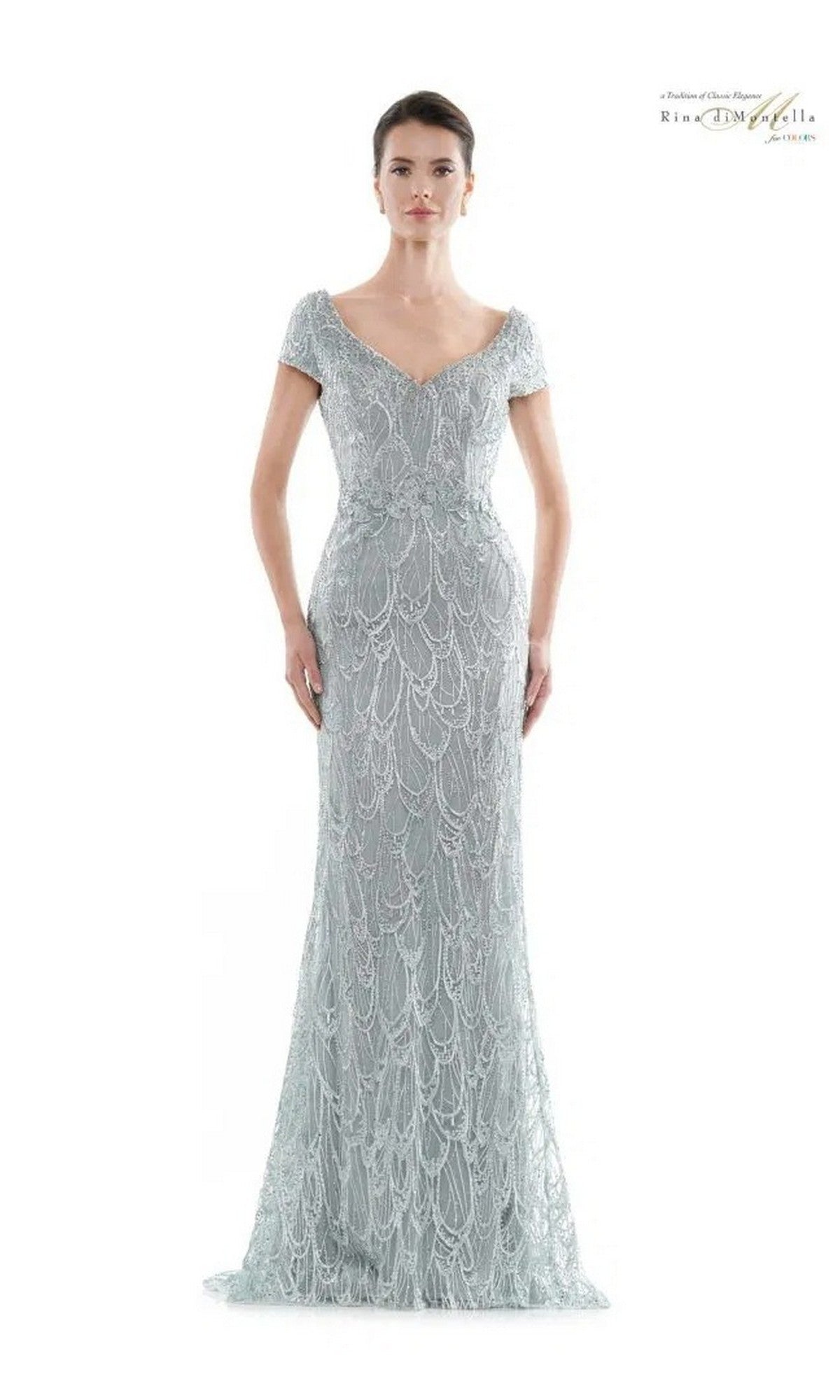 A woman wears the floor-length Rina Di Montella RD2716 long formal dress in Seaglass, featuring short sleeves, a V-neckline, and bead and sequin embellishments, standing against a plain white background.